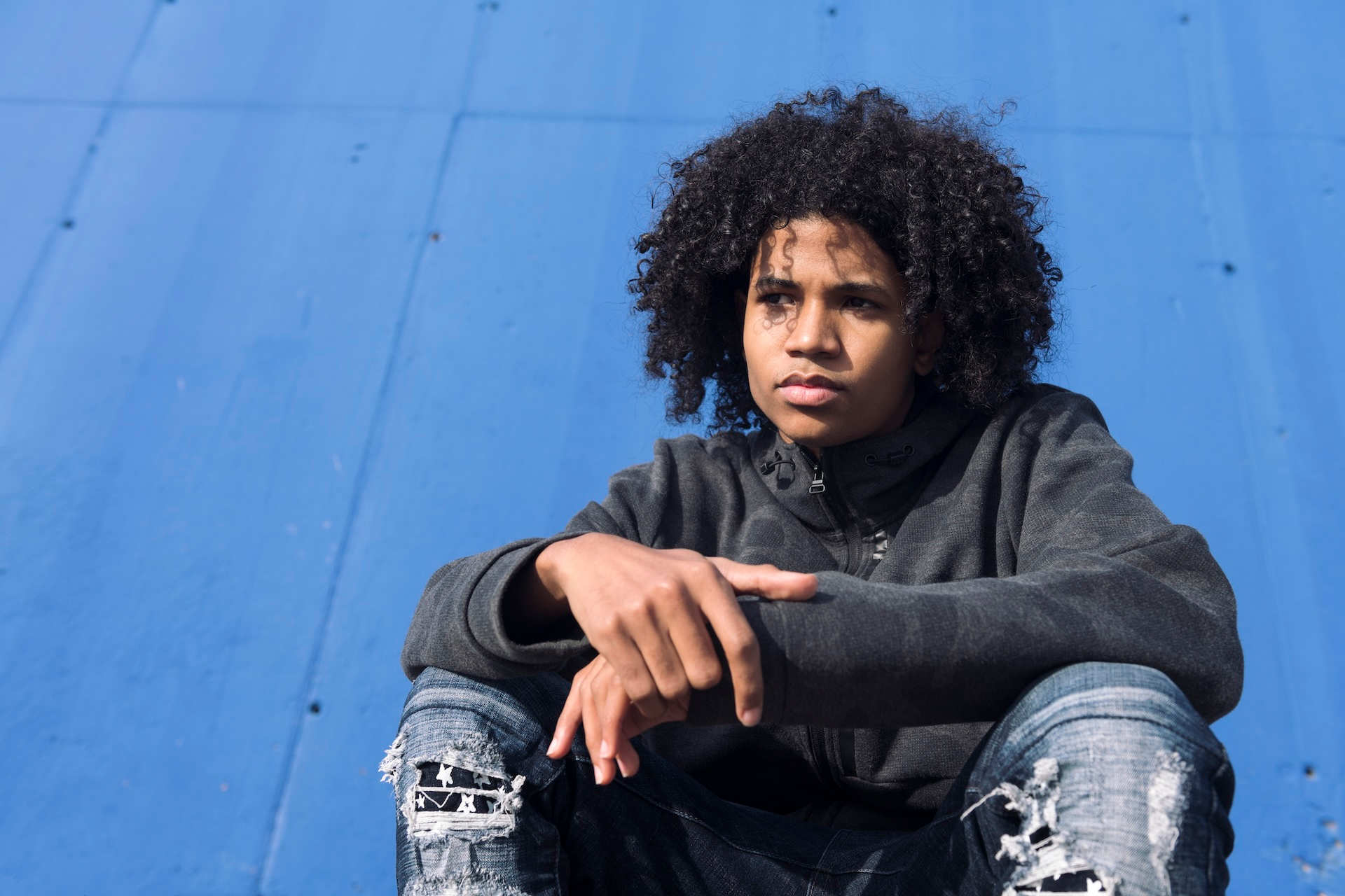 Serious teenager with a black and blue background.